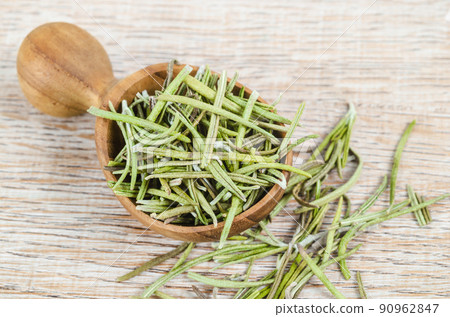 Dried rosemary spice in wooden spoon. Macro with shallow depth of field. 90962847