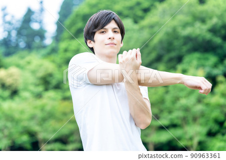 A young man stretching in the fresh green 90963361