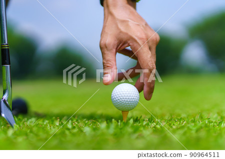 Hand Golfer hold Golf ball with tee ready to be shot at golf court 90964511