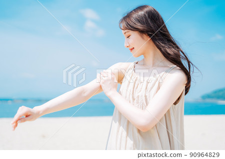 Woman applying sunscreen at sea 90964829