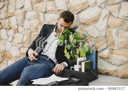 Upset fired european man getting drunk outside 90965317