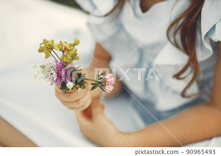 Cropped view of little girl holding flowers Cropped view of little girl holding flowers 90965493