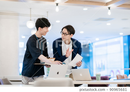 A boss who teaches with a newcomer who is taught work in office casual 90965681