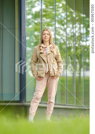 Sporty woman in track suit stands near the glass wall of her condo 90967080
