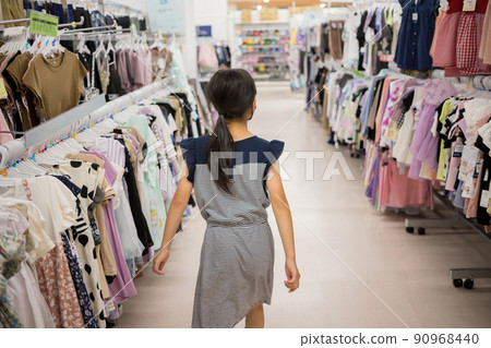 一個小學生在百貨商店的時尚角找衣服 90968440
