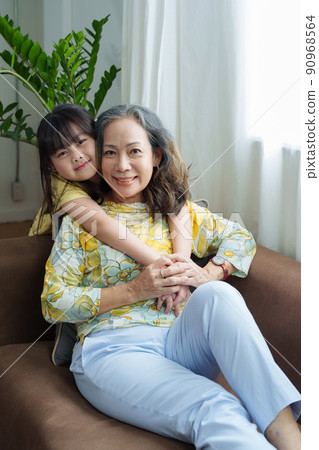 Asian portrait, grandma and granddaughter doing leisure activities and hugging to show their love and care for each other. 90968564
