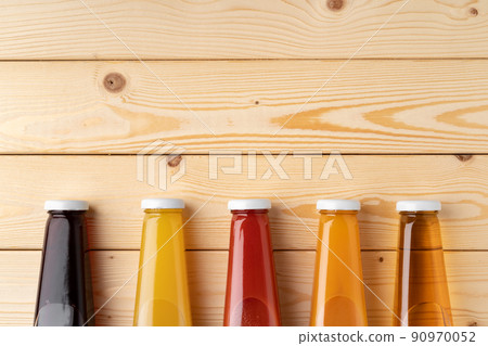 Juice bottles on wooden background flat lay Juice bottles on wooden background flat lay 90970052