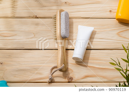 Foot brush and foot cream on wooden background Foot brush and foot cream on wooden background 90970119