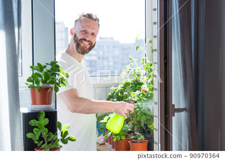 Man growing city balcony garden Man growing city balcony garden 90970364