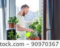 Man growing city balcony garden 90970367