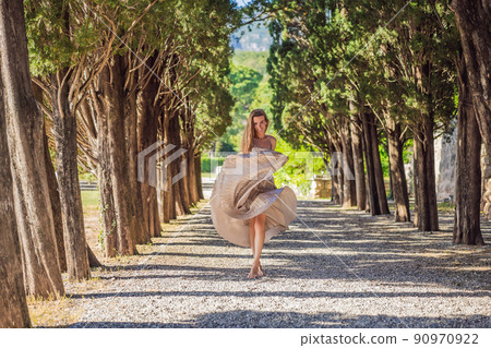 Woman tourist walking in Montenegro. Panoramic summer landscape of the beautiful green Royal park Milocer on the shore of the the Adriatic Sea, Montenegro 90970922