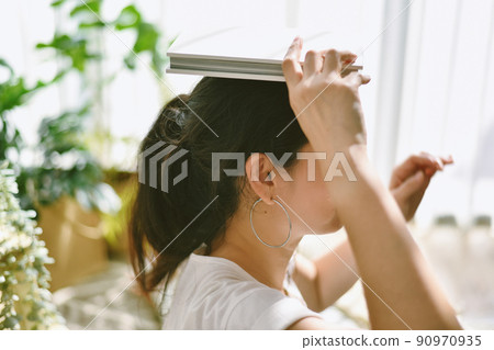 Happy woman holding book on her head with cheerful smile, Reading and relaxing on lazy day Happy woman holding book on her head with cheerful smile, Reading and relaxing on lazy day 90970935