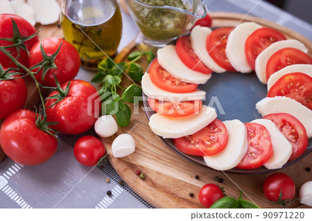 Caprese salad - sliced mozzarella cheese and tomatoes Caprese salad - sliced mozzarella cheese and tomatoes 90971220