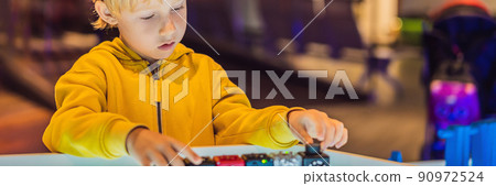The boy plays with the electronic designer on the light table BANNER, LONG FORMAT The boy plays with the electronic designer on the light table BANNER, LONG FORMAT 90972524
