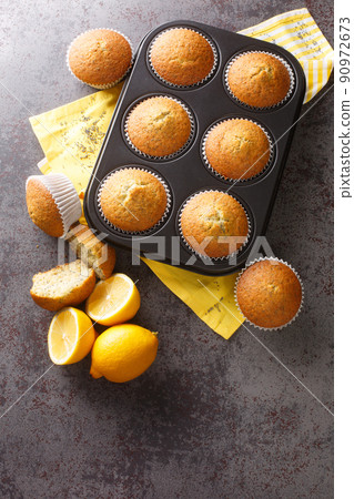 Poppyseed muffins with lemon zest close-up in a metal muffin pan on the table. vertical top view 90972673