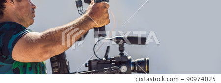 Steadicam operator and his assistant prepare camera and 3-axis stabilizer-gimbal for a commercial shoot BANNER, LONG FORMAT Steadicam operator and his assistant prepare camera and 3-axis stabilizer-gimbal for a commercial shoot BANNER, LONG FORMAT 90974025
