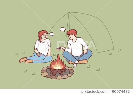Man and woman relaxing near campfire 90974482