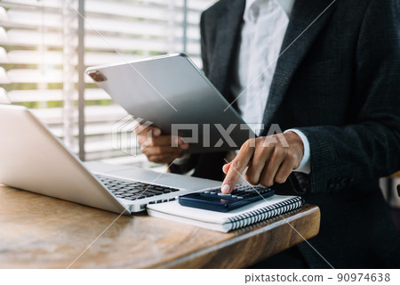 Investors are calculating on calculator investment costs and holding tablet in hand. 90974638