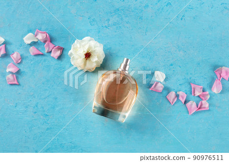Rose fragrance bottle, a luxury product, shot from the top on blue Rose fragrance bottle, a luxury product, shot from the top on blue 90976511