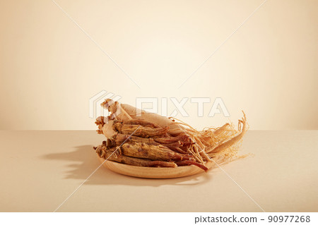 A front view of ginseng decorated in wooden dish in white background  90977268