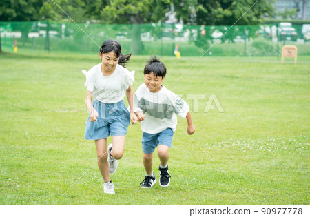 Asian children running in a park rich in nature 90977778