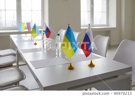 Table with flags of Ukraine and Russia at negotiations aimed at restoring peace between countries 90978213