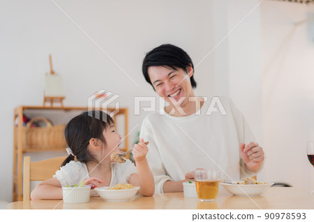 Daddy eating rice with his daughter 90978593