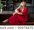Beautiful adult woman sitting in the kitchen 90978876