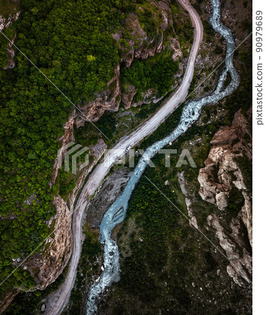 Top view of mountain road in forest with blue river Top view of mountain road in forest with blue river 90979689