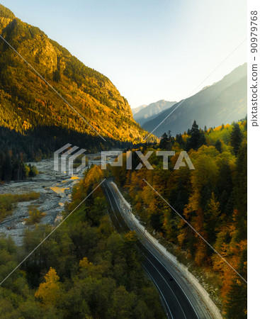 Mountain road going into the distance next to the river 90979768