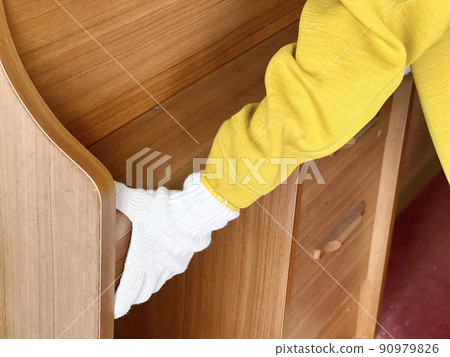 Hands with work gloves carrying a study desk Hands with work gloves carrying a study desk 90979826