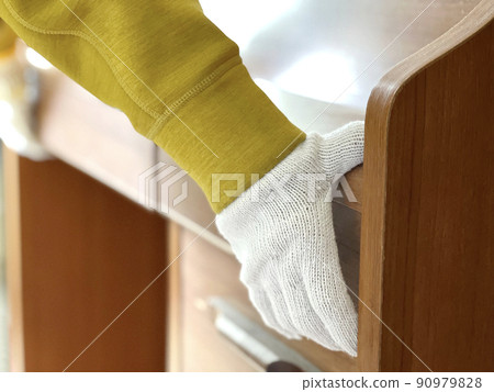 Hands with work gloves carrying a study desk 4 Hands with work gloves carrying a study desk 4 90979828