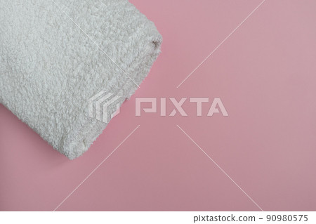 A white terry towel on a pink background with a place for text. Purity. A white terry towel on a pink background with a place for text. Purity. 90980575