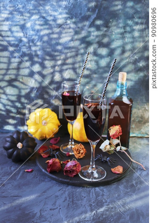 Halloween, wine in glasses and a bottle, pumpkins, mystical decorations, dry rose flowers, on a black background, shadows in the form of a cobweb, the concept of the atmosphere of a party, holiday Halloween, wine in glasses and a bottle, pumpkins, mystical decorations, dry rose flowers, on a black background, shadows in the form of a cobweb, the concept of the atmosphere of a party, holiday 90980696