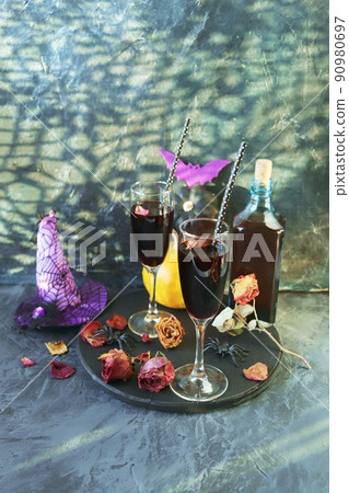 Halloween, wine in glasses and a bottle, pumpkins, mystical decorations, dry rose flowers, on a black background, shadows in the form of a cobweb, the concept of the atmosphere of a party, holiday Halloween, wine in glasses and a bottle, pumpkins, mystical decorations, dry rose flowers, on a black background, shadows in the form of a cobweb, the concept of the atmosphere of a party, holiday 90980697