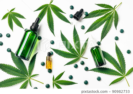 Top view of green hemp leaves with cosmetics glass reusable bottles. Medical and Recreational Use of Marijuana. Natural cosmetics or superfood 90982733