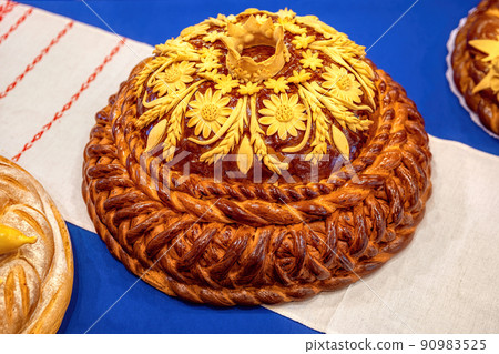 Traditional ukrainian wedding bread on an embroidery towel. Round loaf wedding bread. Traditional ukrainian wedding bread on an embroidery towel. Round loaf wedding bread. 90983525