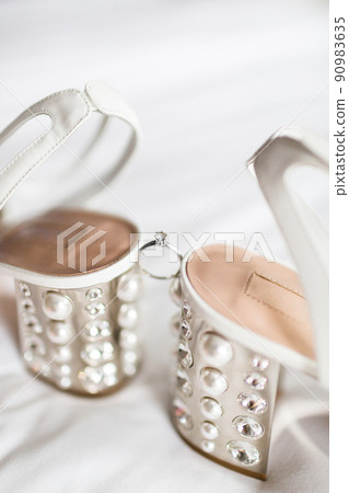 Wedding ring between wedding shoes and highlights Wedding ring between wedding shoes and highlights 90983635