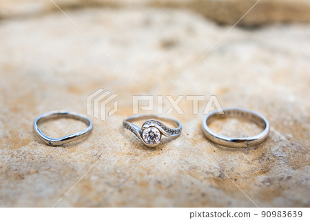 Three wedding ring on a stone background Three wedding ring on a stone background 90983639