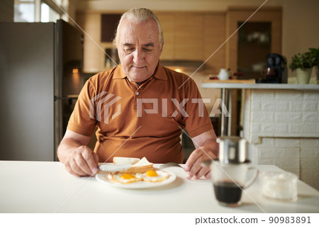 Senior Man Eating Fried Eggs 90983891