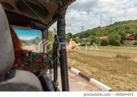 Safari park. View from a tourist jeep. The woman put her hand out the window, showing the cool sign. Touristic adventure Safari park. View from a tourist jeep. The woman put her hand out the window, showing the cool sign. Touristic adventure 90984455
