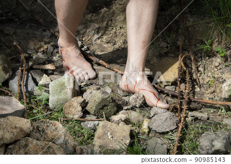 Wounded feet walk a hard rocky path Wounded feet walk a hard rocky path 90985143