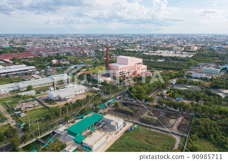 Aerial view of stack of different types of large garbage pile, plastic bags, and trash with a tractor car in industrial factory in environmental pollution. Waste disposal in dumping site. 90985711