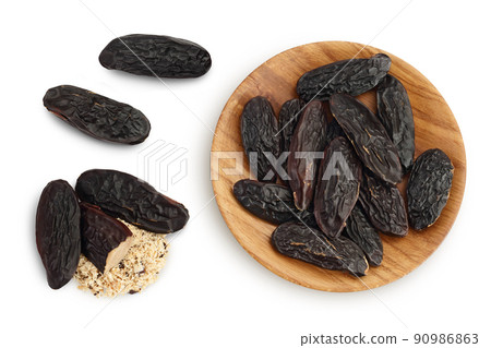 Tonka bean in wooden bowl isolated on white background with full depth of field. Bean of Dipteryx odorata. Top view. Flat lay 90986863