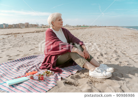 Calm pensive lady seated by the sea Calm pensive lady seated by the sea 90986986