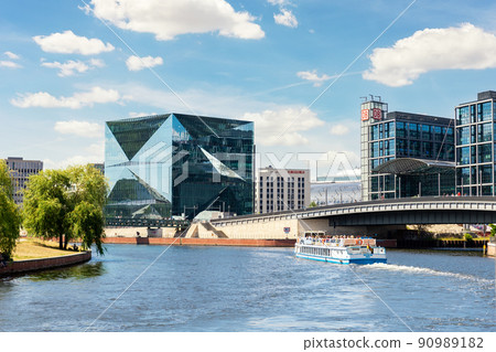 Scenic panoramic view of modern business center near Berlin DB railway central station from tourist ship sailing on river Spree on sunny day. Germany travel destiantaion.June 16th - Berlin, Germany Scenic panoramic view of modern business center near Berlin DB railway central station from tourist ship sailing on river Spree on sunny day. Germany travel destiantaion.June 16th - Berlin, Germany 90989182