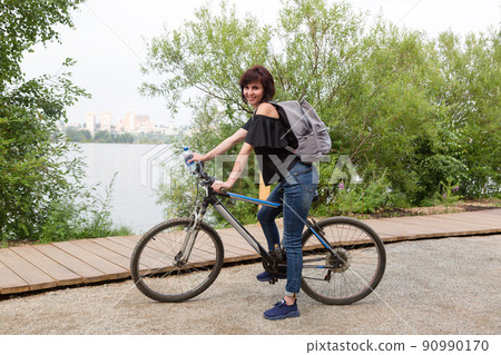 Girl tourist on a bicycle stopped to rest Girl tourist on a bicycle stopped to rest 90990170