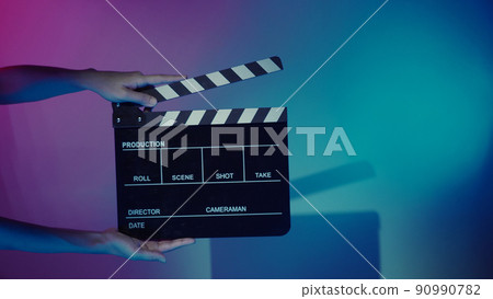 Movie Clapper board. Crew hand holding plastic and wooden film slate board against camera. Movie clapperboard using in video production and movie studio works film industry. Film slate on crew hand. 90990782