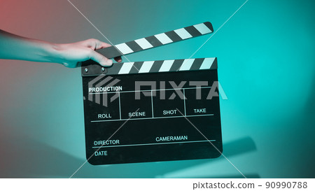 Movie Clapper board. Crew hand holding plastic and wooden film slate board against camera. Movie clapperboard using in video production and movie studio works film industry. Film slate on crew hand. 90990788