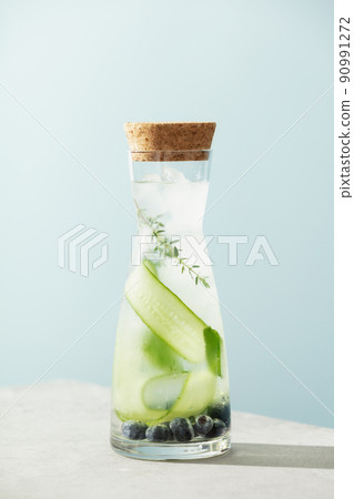 Summer drink with cucumber, blackberry and rosemary on blue sky background, healthy infused vitamin water Summer drink with cucumber, blackberry and rosemary on blue sky background, healthy infused vitamin water 90991272